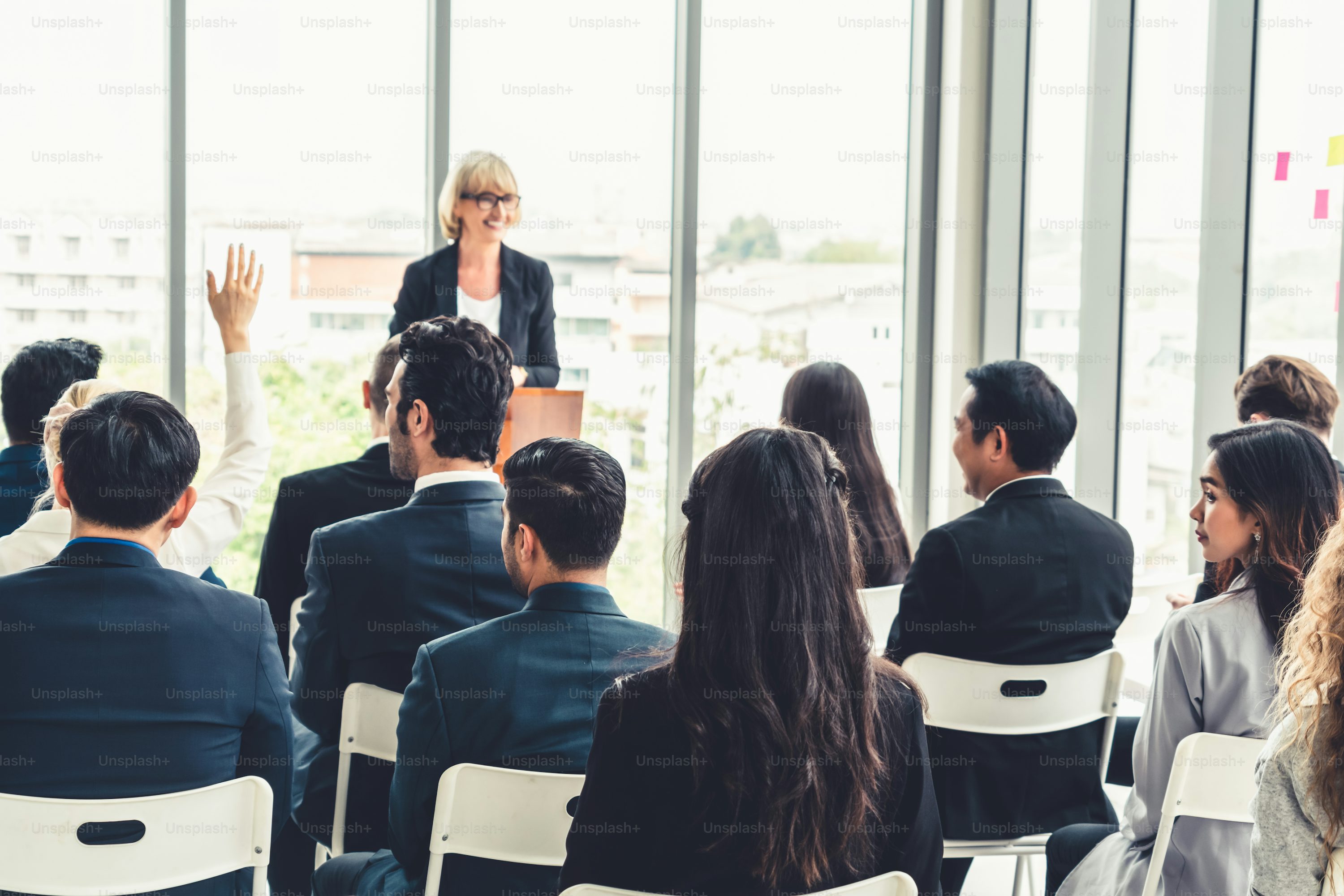 Woman speaking to group of people sitting down listening to her speak